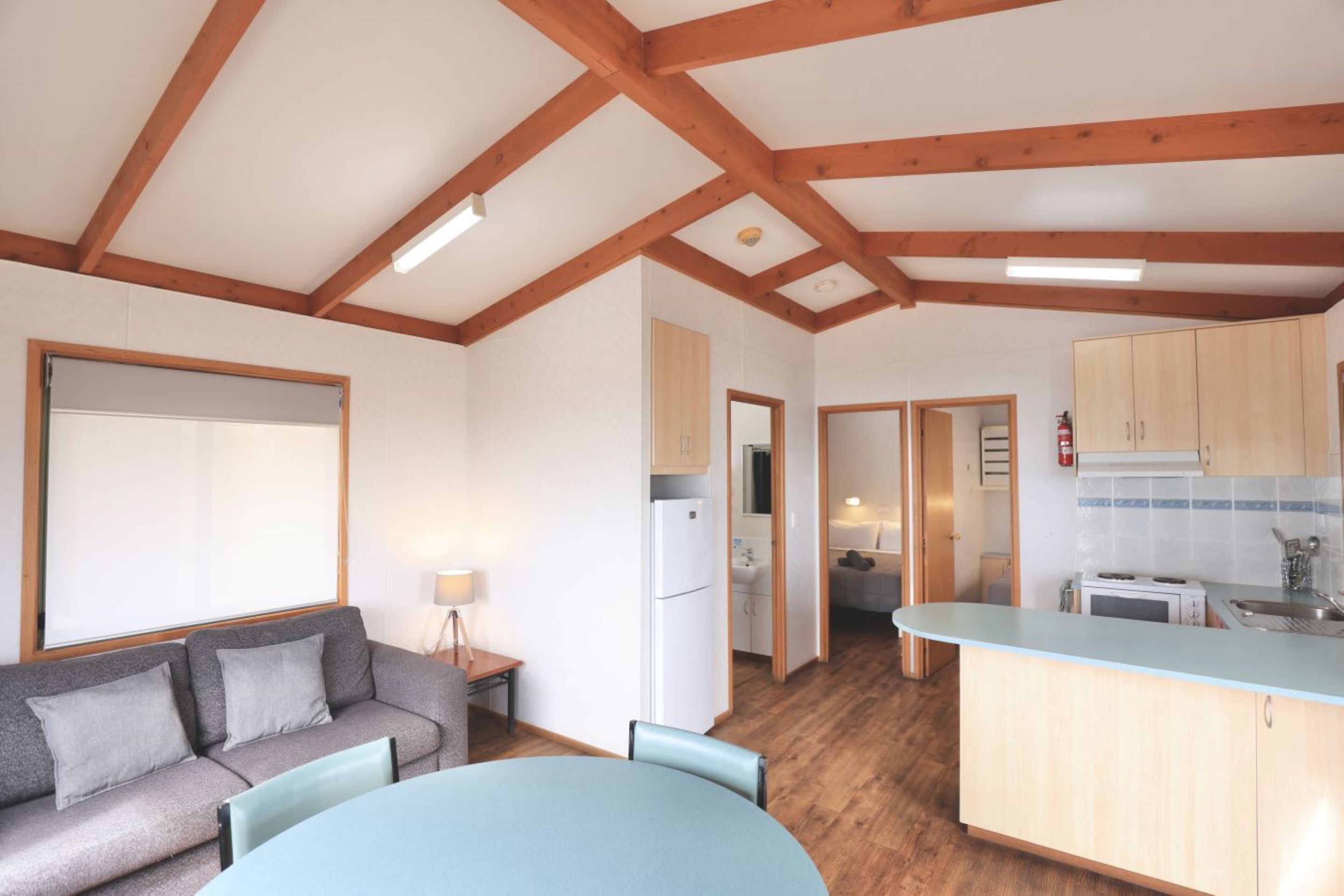 A compact living space with a kitchenette, a dining area, and a sofa.