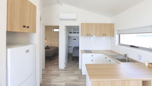 A modern kitchen with wooden cabinets, a built-in sink, and a window.