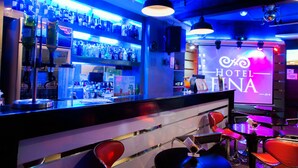 A bar area with a neon sign reading "HOTEL FINA" and various bottles on shelves. - Hotel Fina (Tabaco City)