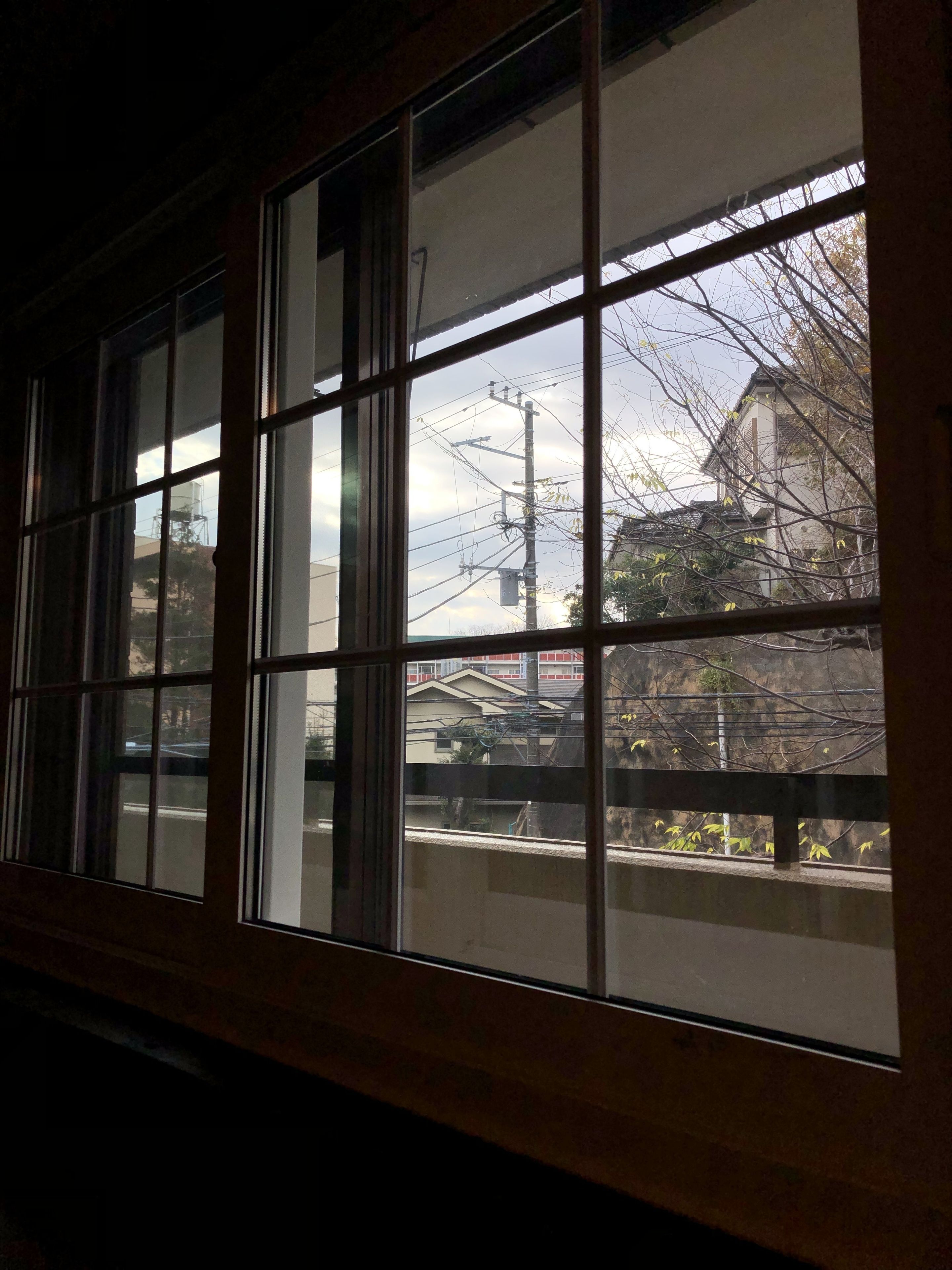 A window with a view of a building and power lines.