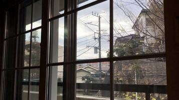 A window with a view of a building and power lines.