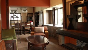 Un salón amplio con chimenea, una mesa de comedor y una zona de estar con sofá y sillones.
