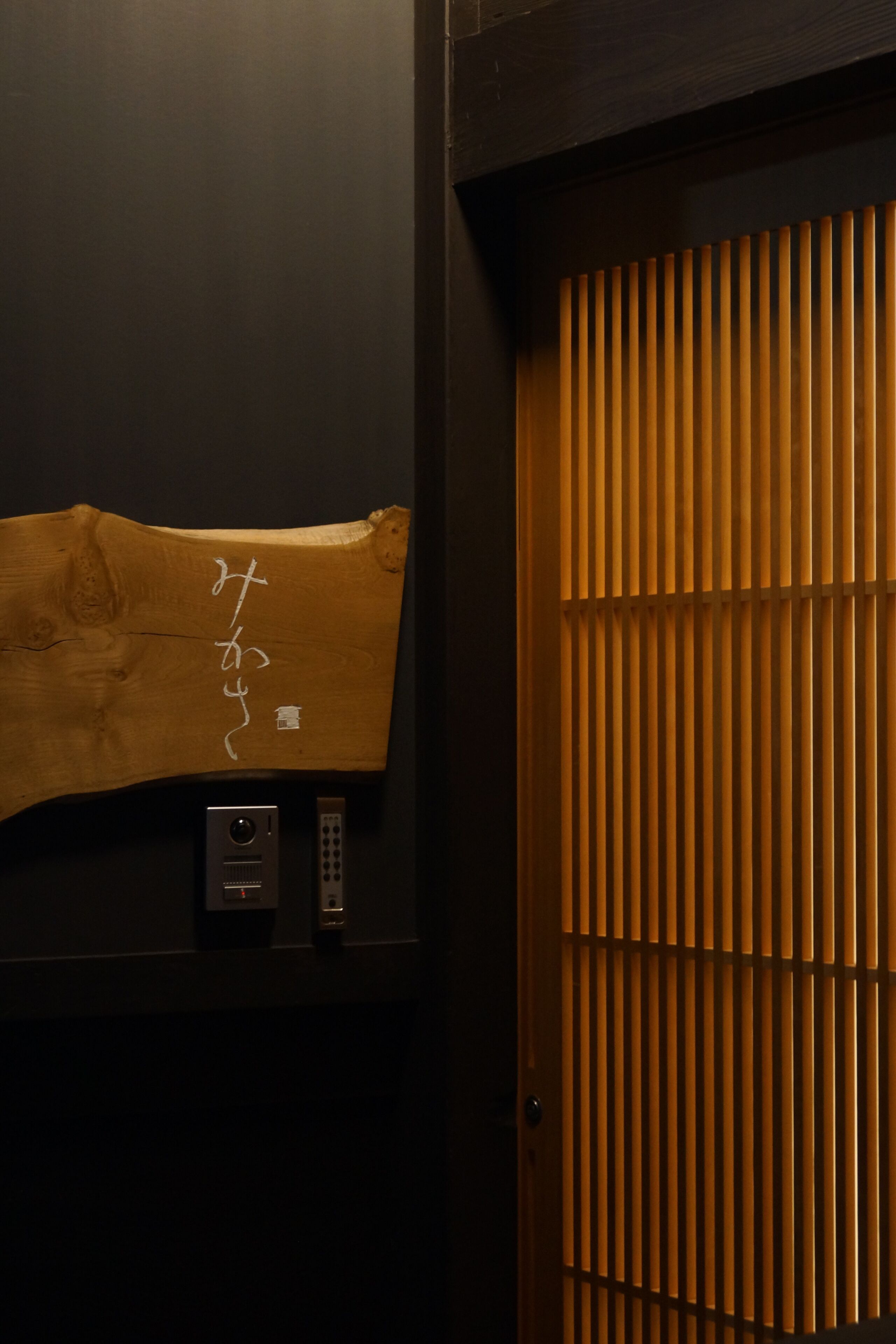 A wooden door with vertical slats and a control panel below it.