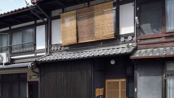 En traditionell japansk byggnad med ett tak täckt av tegelpannor, träbjälkar och en skjutdörr.