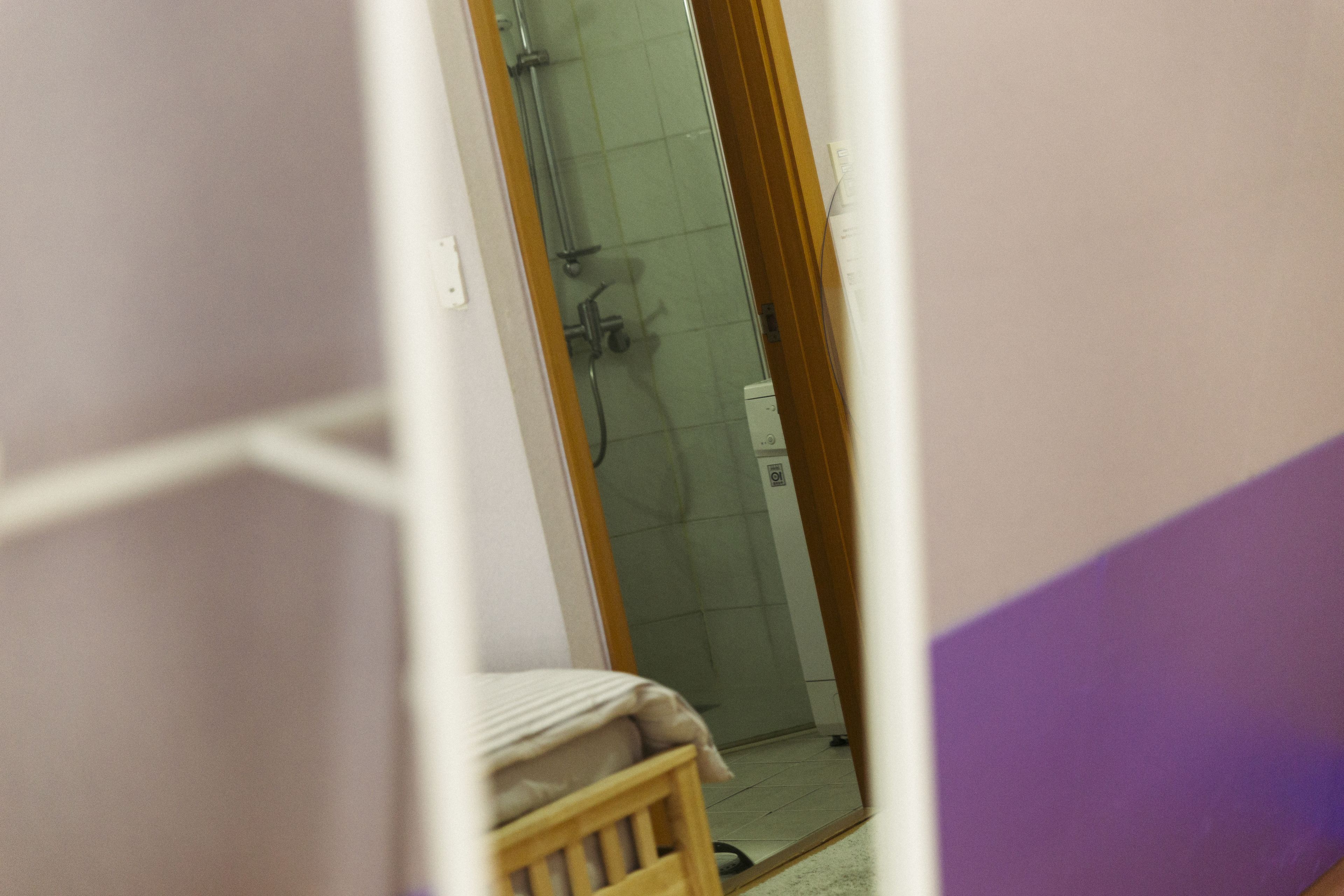 Ein Badezimmer mit Dusche, Toilette und einem Holzstuhl.