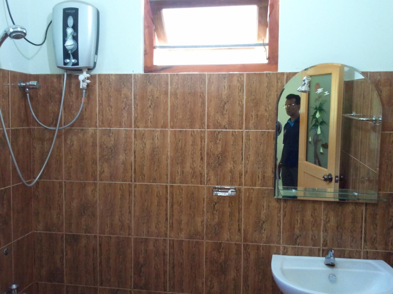 A bathroom with a shower, a sink, and a mirror.