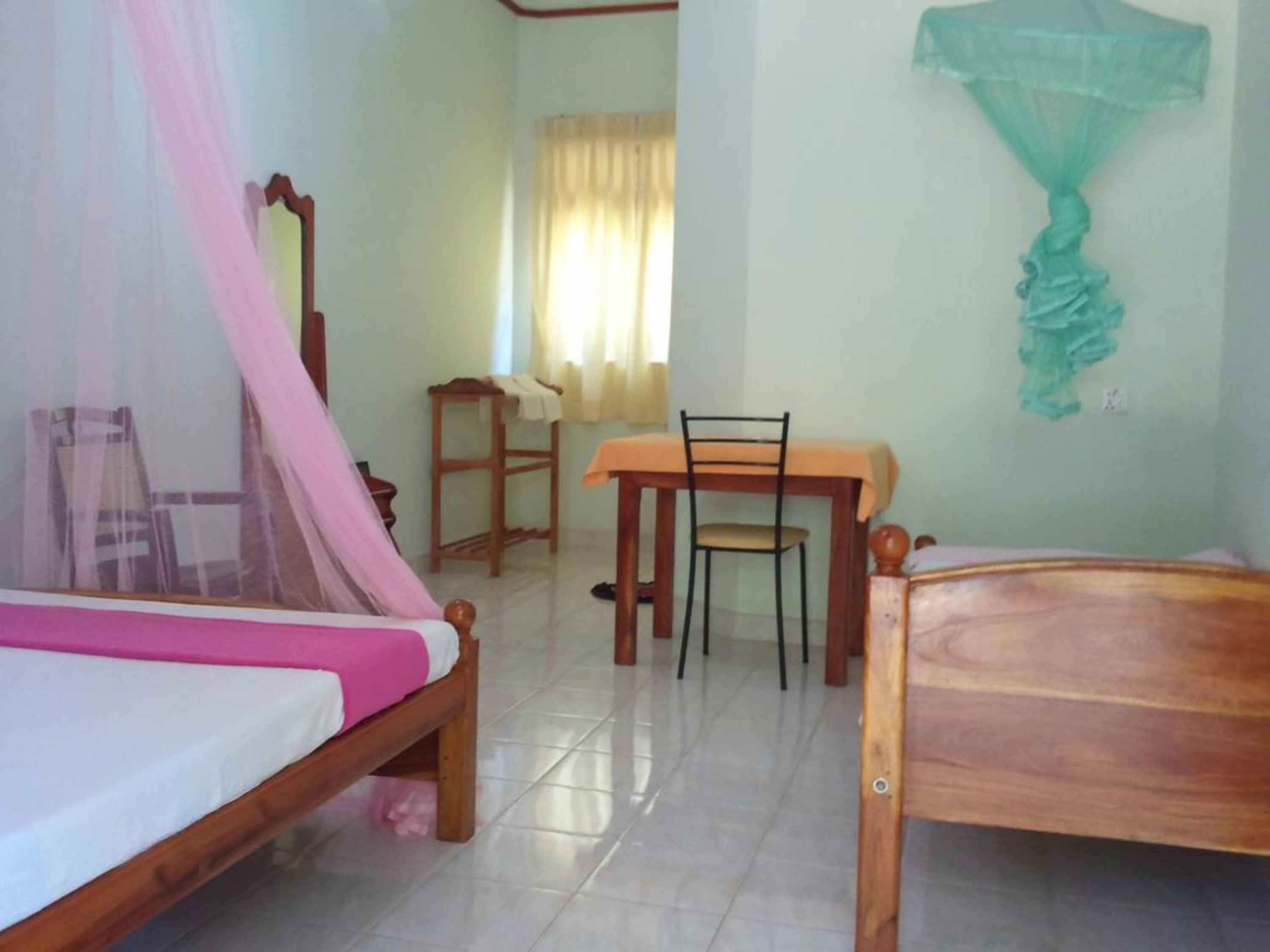 A room with a bed, a table, and a chair.