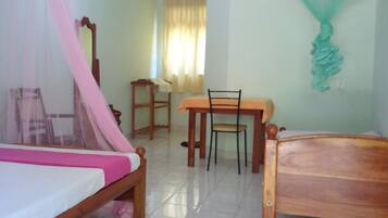 A room with a bed, a table, and a chair.