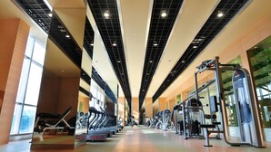 A gym with treadmills, weight machines, and mirrors.