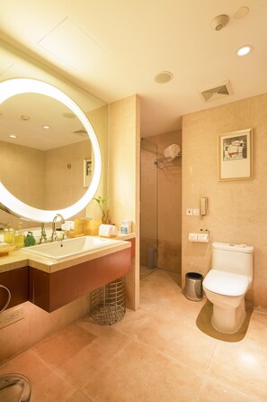 Une salle de bain moderne avec un grand miroir, un lavabo et des toilettes.