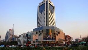 A tall hotel with a modern design, featuring a prominent glass facade and a distinctive triangular top.