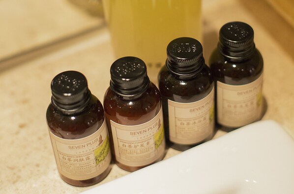 Cuatro botellas de loción hidratante corporal Seven Plus London sobre una encimera.