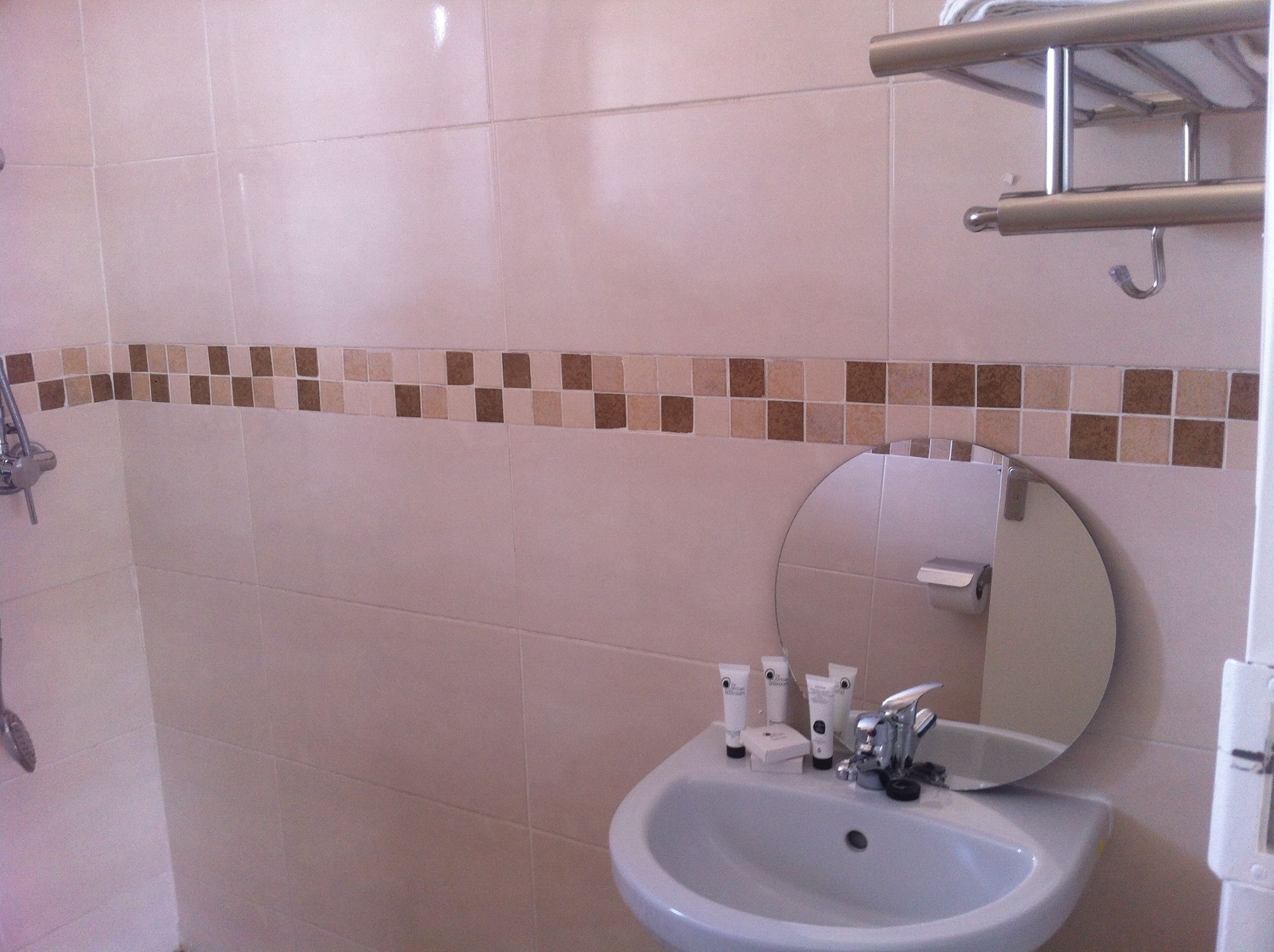 Une salle de bain équipée d’un lavabo, d’un miroir et d’articles de toilette.