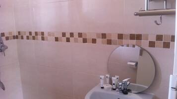 A bathroom with a sink, mirror, and toiletries.