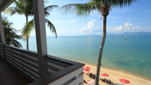 A beach view with palm trees, a sandy shore, and a boat in the distance. - Anjali (Koh Samui)