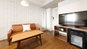 Een moderne woonkamer met een metselwerkmuur, een houten bank, een televisie en een minibar.