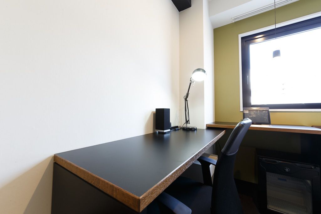 Un escritorio moderno con una computadora, una lámpara y una silla.