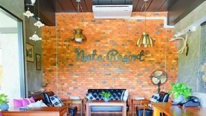 Un restaurante acogedor con pared de ladrillo, muebles de madera y una zona de estar central.