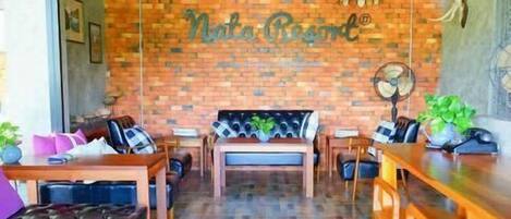 A cozy restaurant with a brick wall, wooden furniture, and a central seating area.