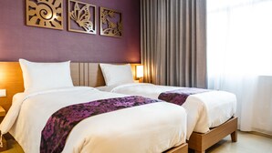 A hotel room with two beds, a wooden headboard, a large window with curtains, and wall art. - Asialink Easy by Prasanthi (Batam)