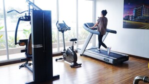 A gym with a treadmill, stationary bike, and weight machine. - Asialink Easy by Prasanthi (Batam)