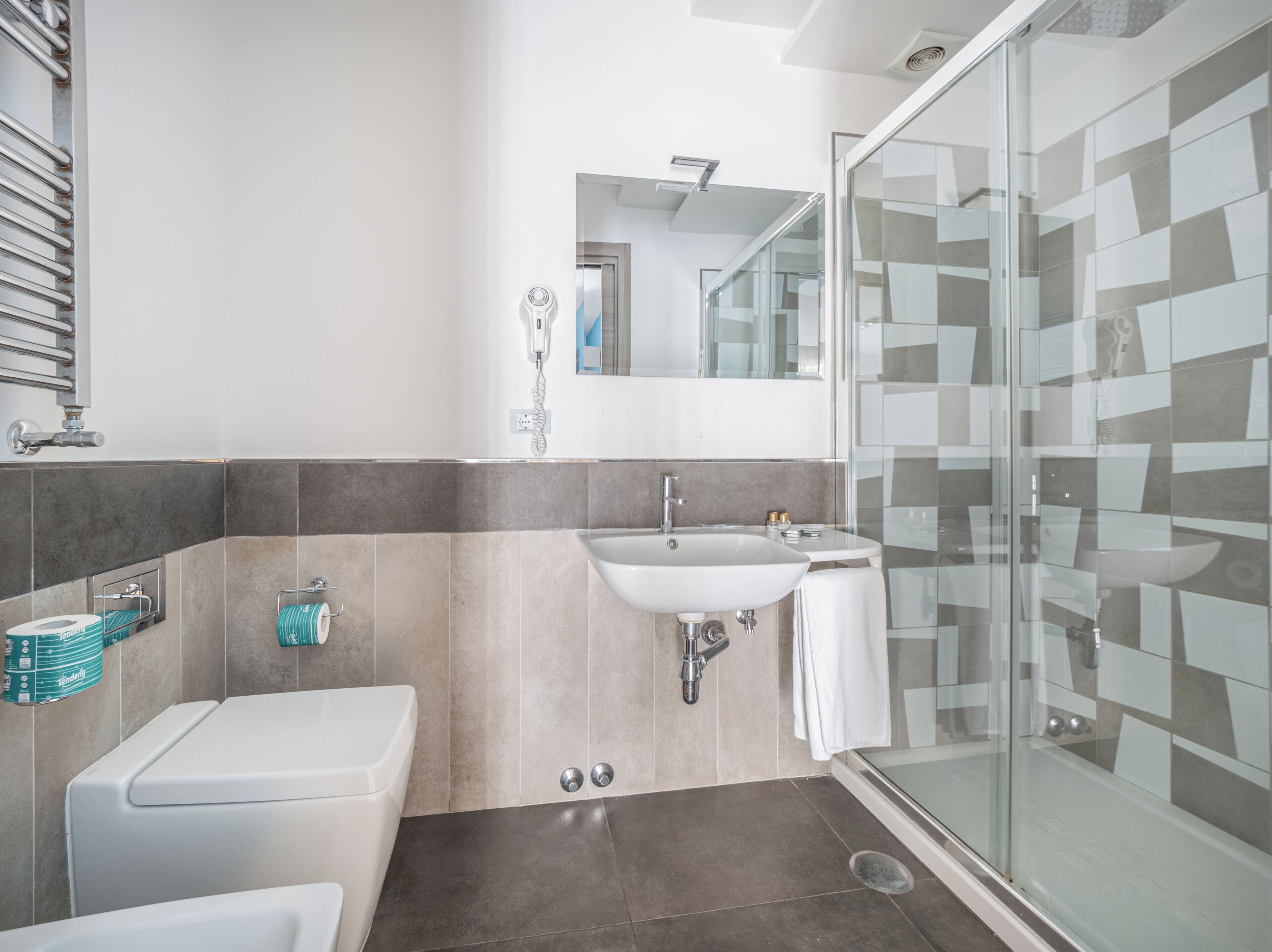 A modern bathroom with a toilet, sink, and shower.