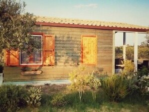 A wooden cabin with a tiled roof, two wooden doors, and a small window.