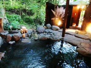 A serene outdoor setting with a small pond, stone pathway, and wooden structures. - Hotel Rokusui-Rou (Ito)