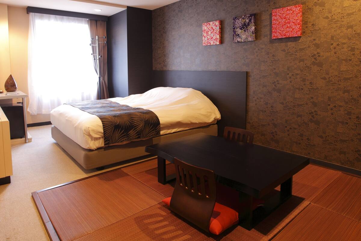 Una habitación de hotel con una cama, un escritorio y una mesa.