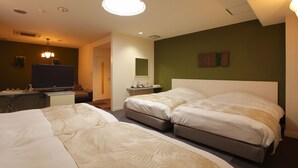 Une chambre d’hôtel avec deux lits, une télévision, un bureau et une petite table.
