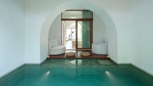 A modern bathroom with a large bathtub, a white sofa, and a glass-enclosed shower area. - SALA Samui Chaweng Beach Resort (Koh Samui)