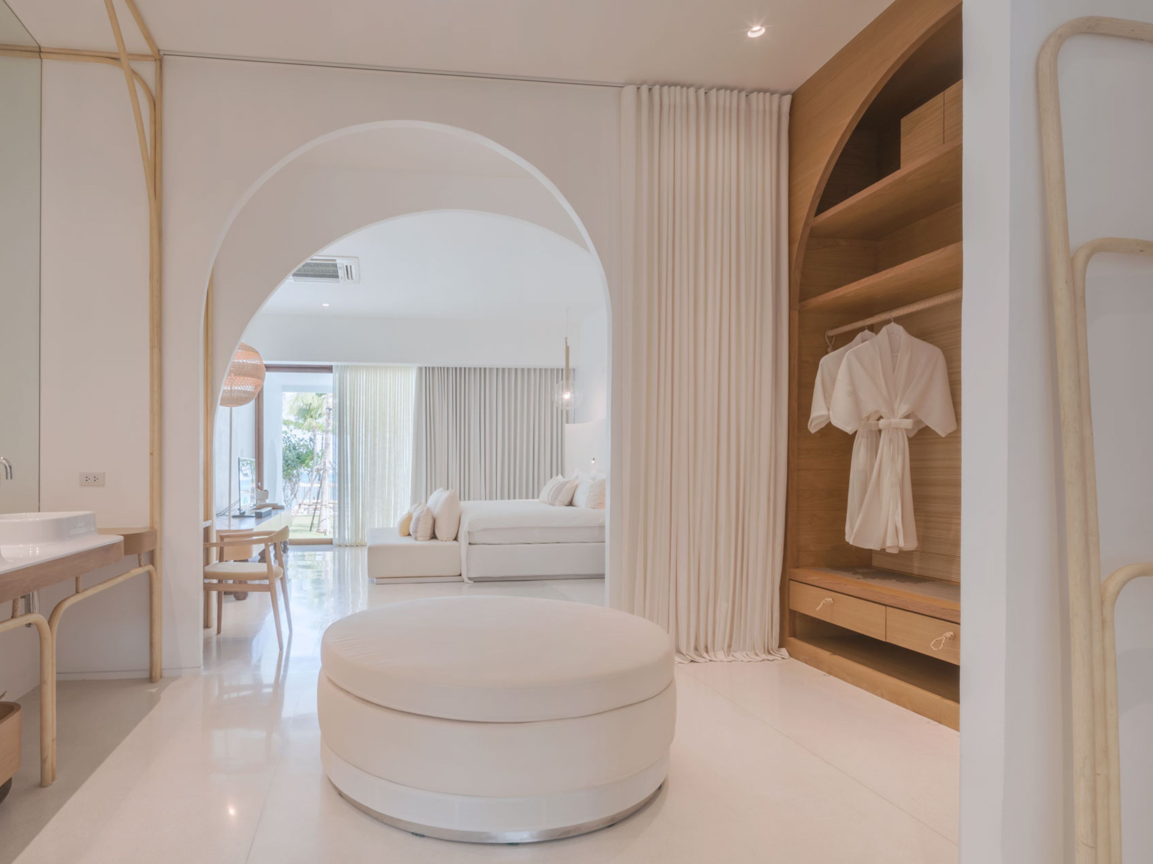 A modern bathroom with a round bathtub, a vanity with a mirror, and a shower area.