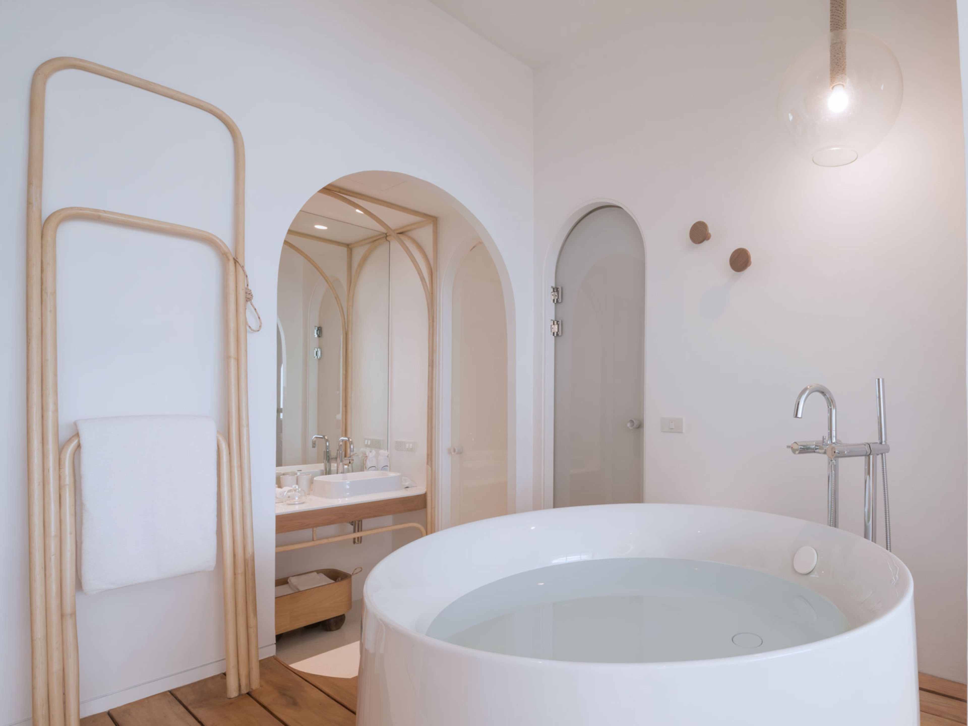 A modern bathroom with a freestanding bathtub, a shower, and a vanity with a mirror.