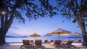 Nyilvános parton, napozóágyak, napernyők és strandlepedők