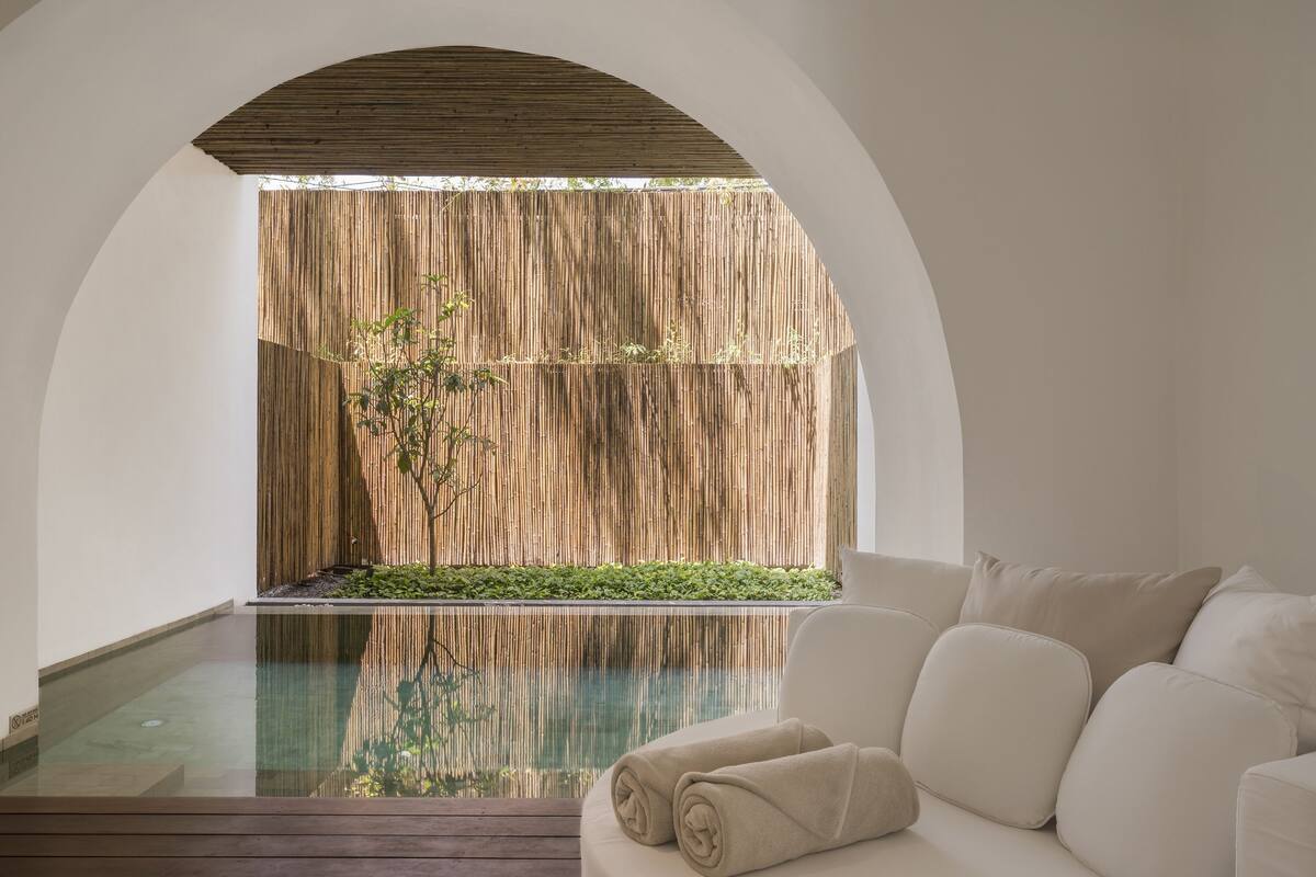 Un espace spa avec un mur en bois, une piscine et un canapé blanc.