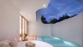 Une chambre moderne avec un grand lit, une petite piscine et une vue sur le ciel.