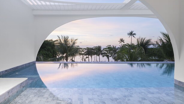 A modern infinity pool with a clear view of the ocean and palm trees, framed by white architecture. - SALA Samui Chaweng Beach Resort (Koh Samui)