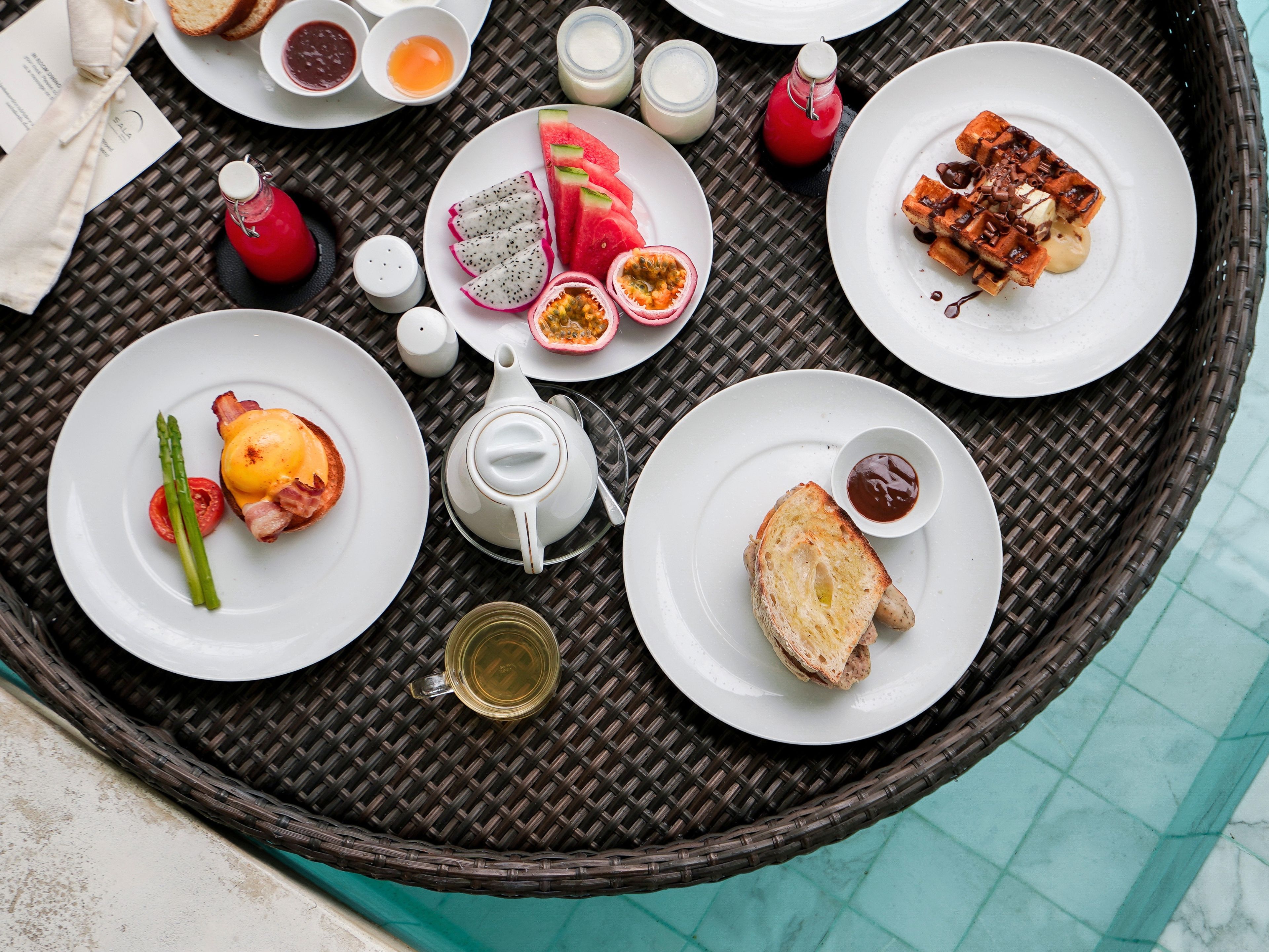 A round dining table with various breakfast items and condiments.