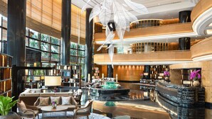 A spacious lobby with a central seating area, a fountain, and a reception desk.