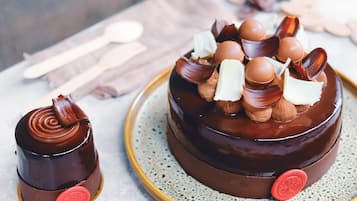Un pastel de chocolate con nueces y bolitas de chocolate sobre un plato.