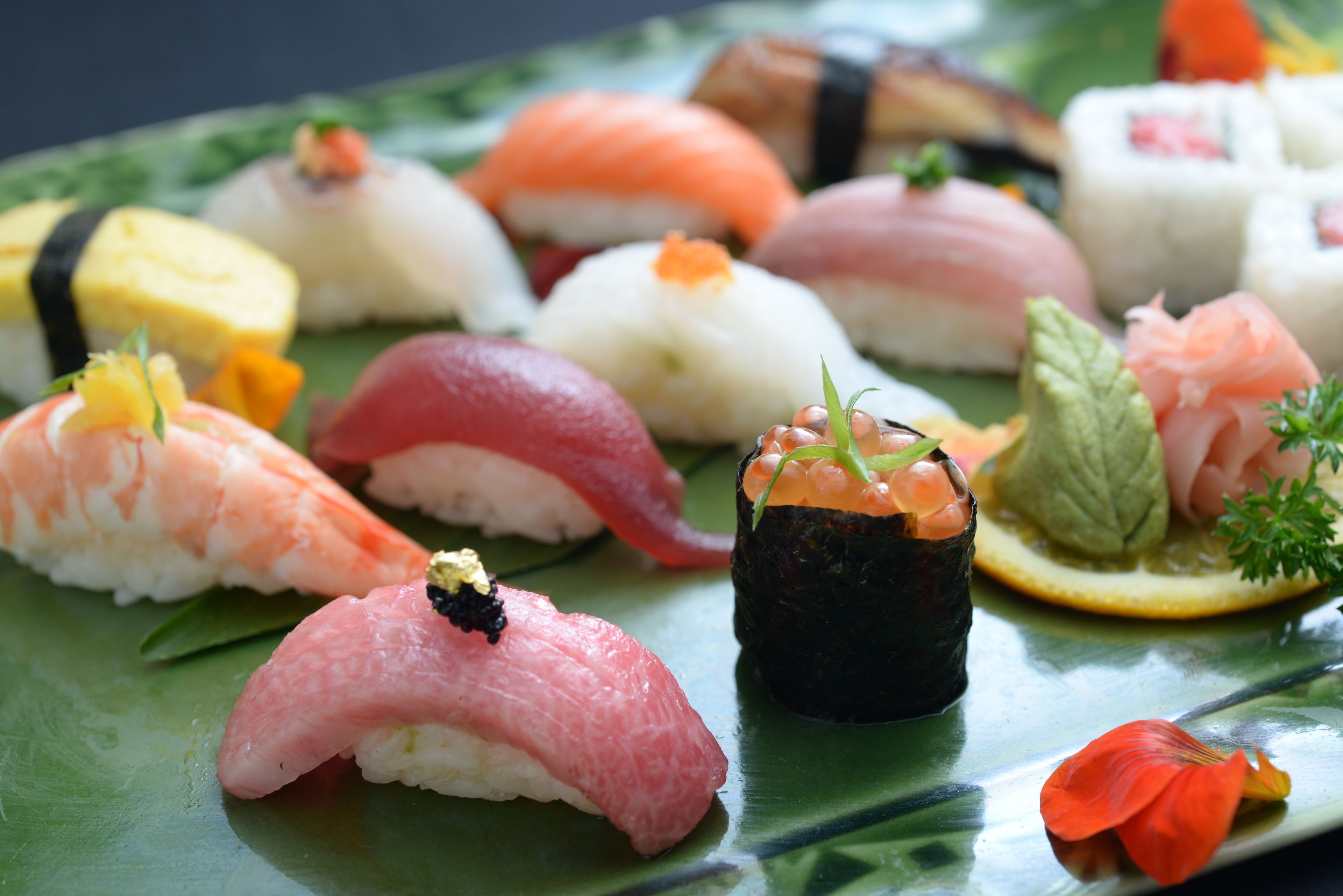 A variety of sushi on a green plate.