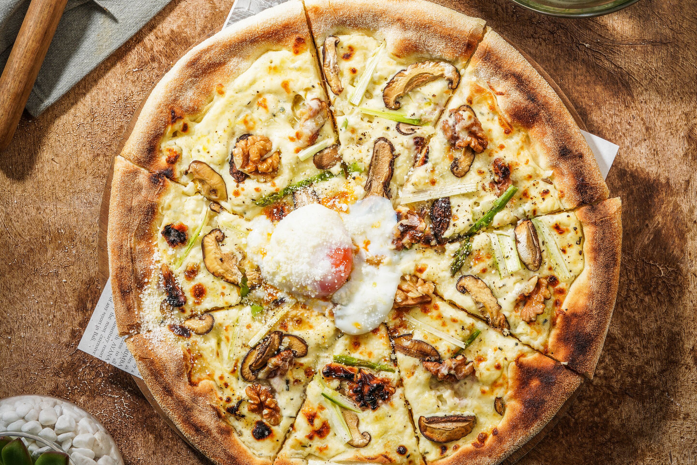 A pizza with toppings on a wooden surface.