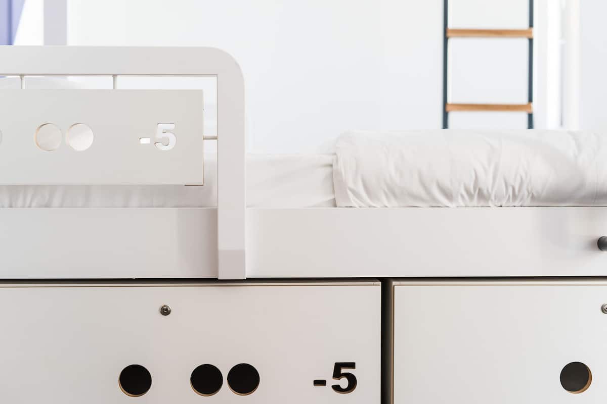 Ein weißes Bett mit Kopfteil, Nachttisch und Beistelltisch.