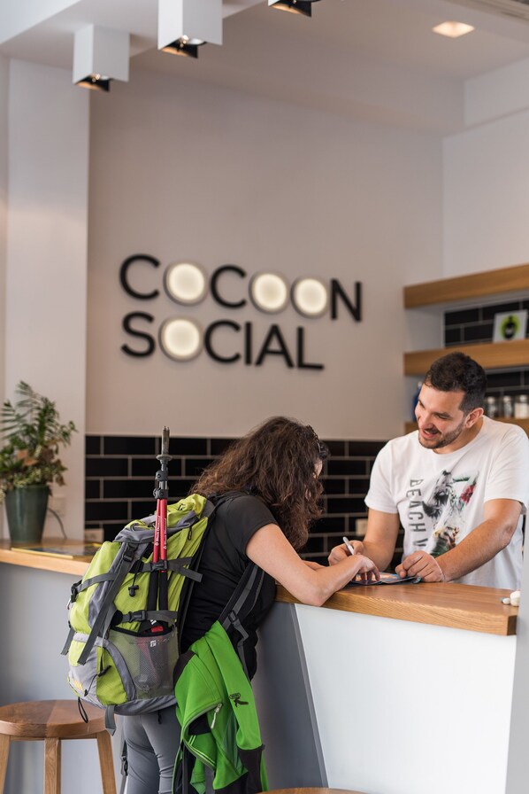 A reception desk with a sign reading "Cocoon Social" in the background.