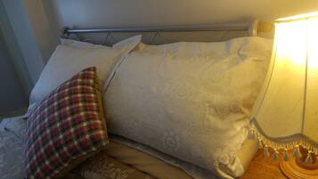 A bed with patterned pillows and a bedside lamp.