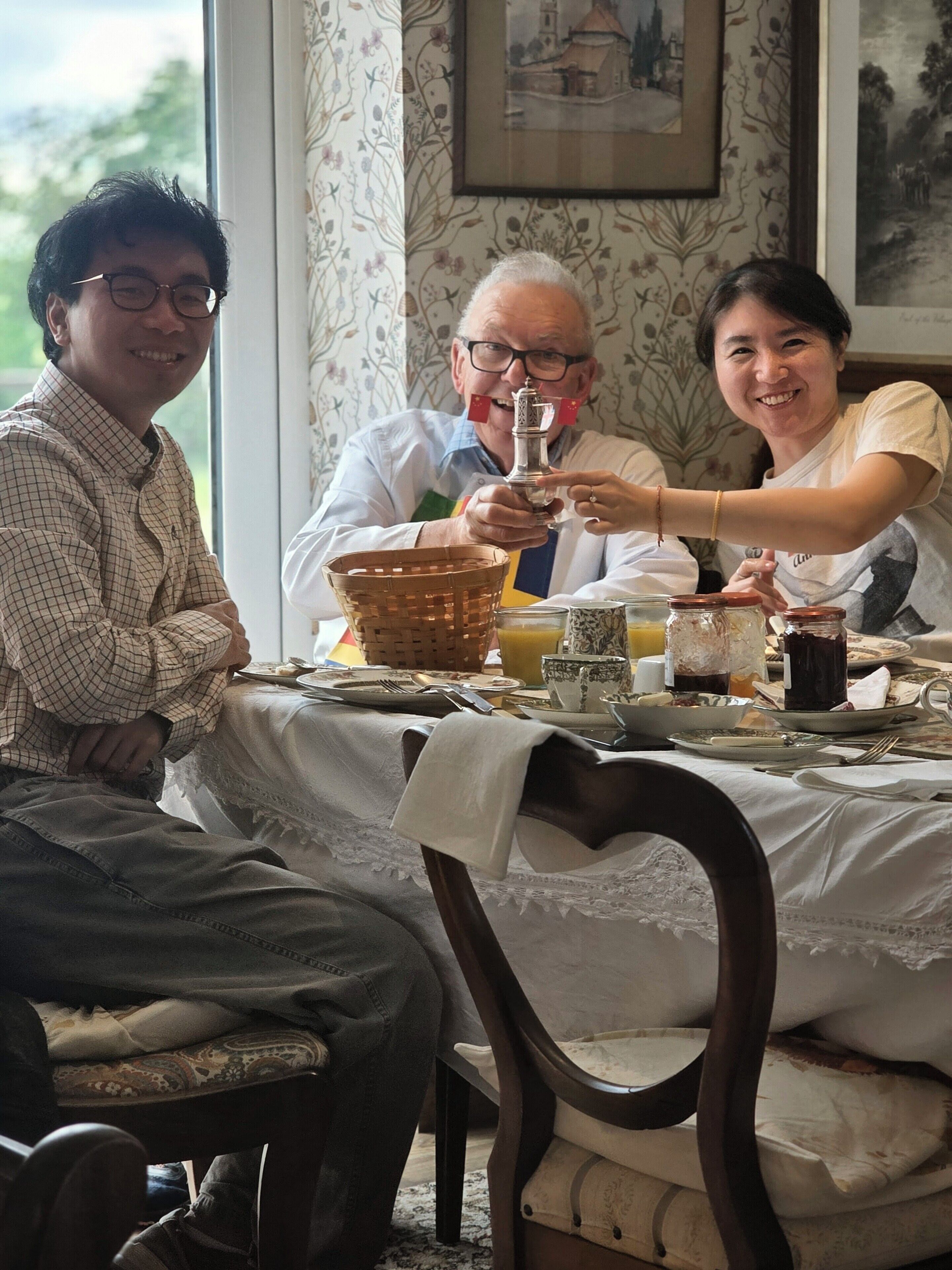 A dining table with a white tablecloth, plates, glasses, and a basket.