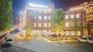 A hotel with a modern facade, multiple floors, and a well-lit entrance.