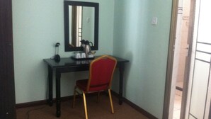 A small room with a desk, chair, and a mirror on the wall. - Exec Closets Hotel (Gaborone)