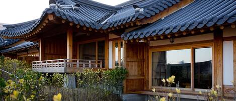 A traditional wooden building with curved tiled roofs and large windows.