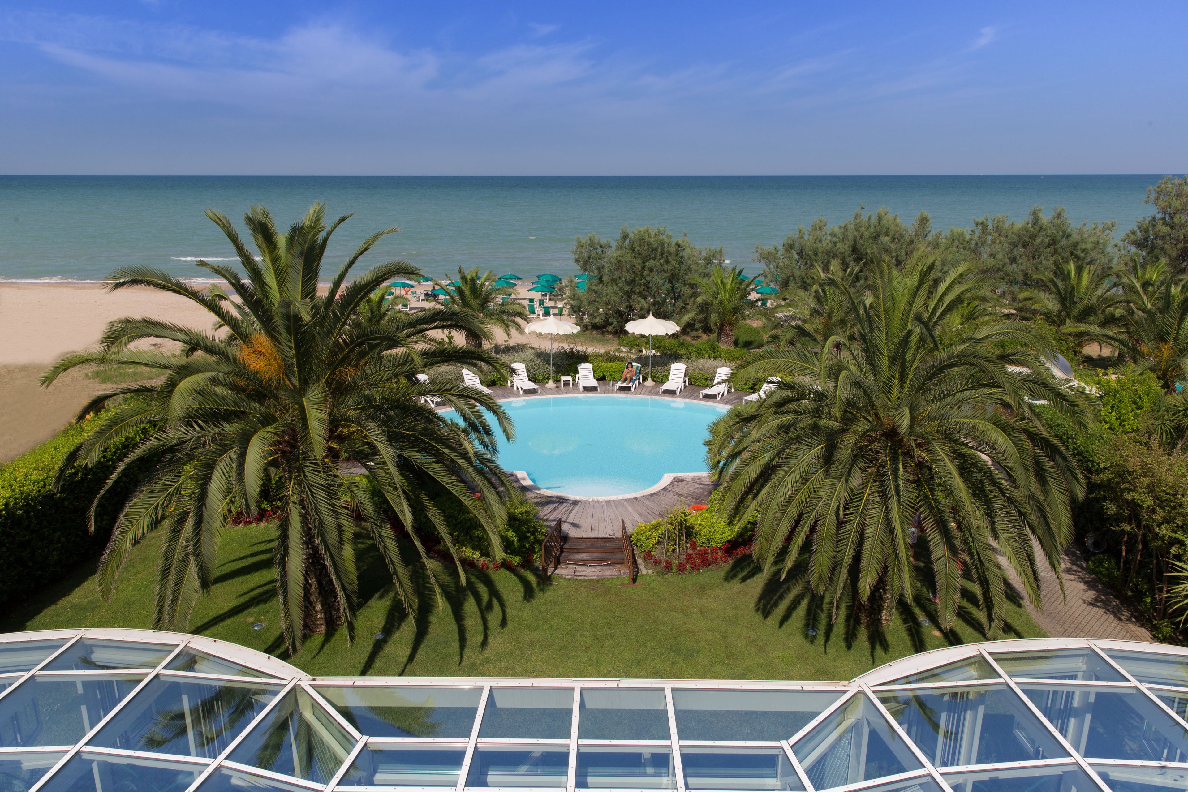 Ein Resort mit Pool, Palmen und Meerblick.
